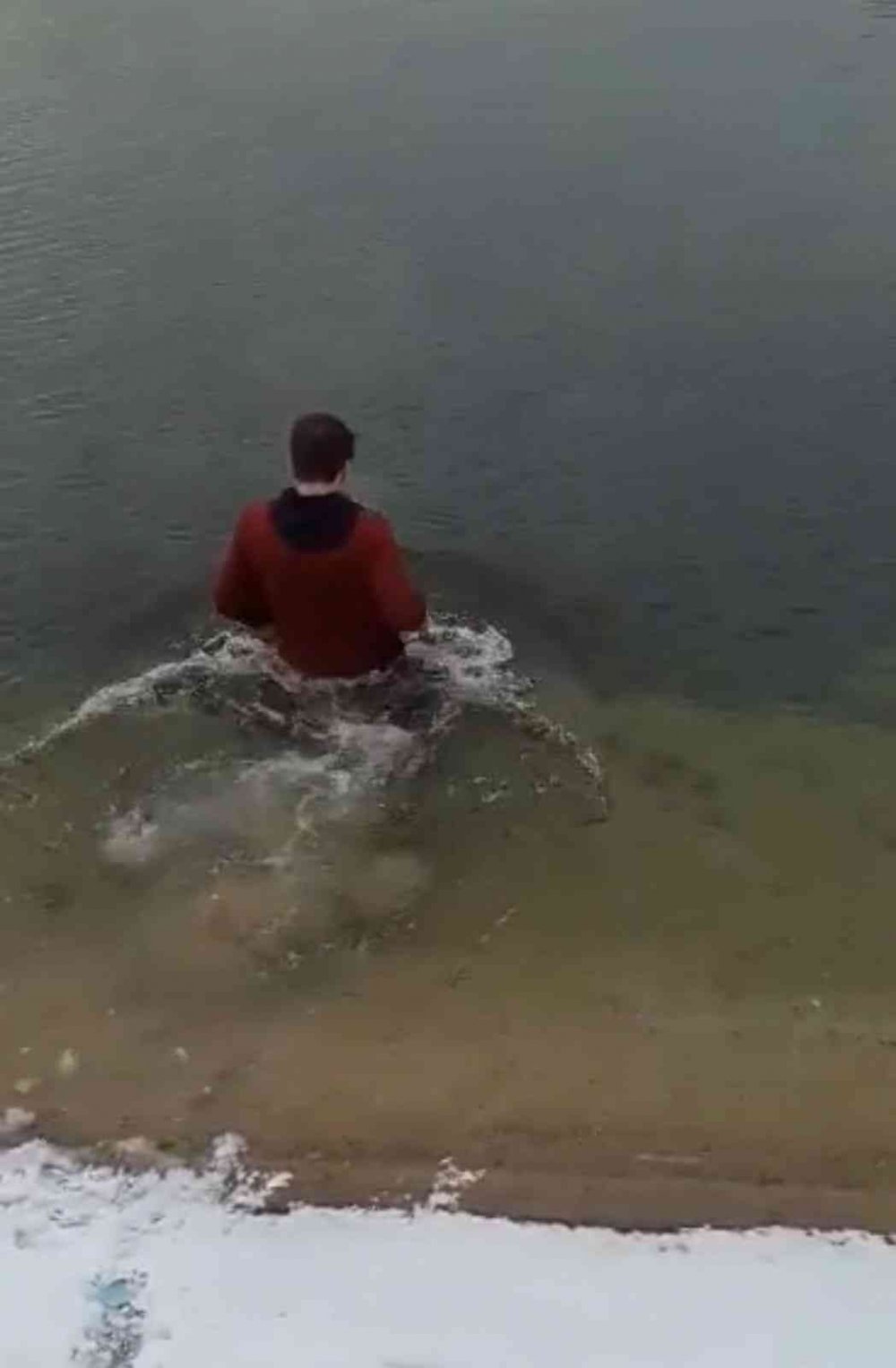 Telefonunu düşüren gencin buz gibi göle daldığı anlar kamerada