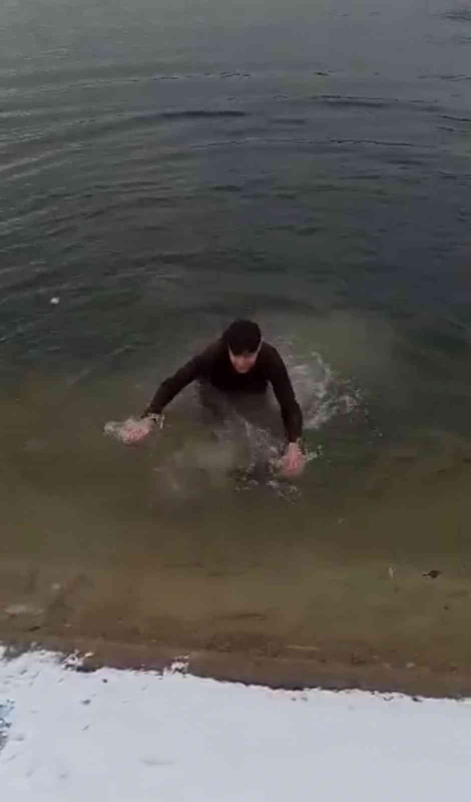 Telefonunu düşüren gencin buz gibi göle daldığı anlar kamerada